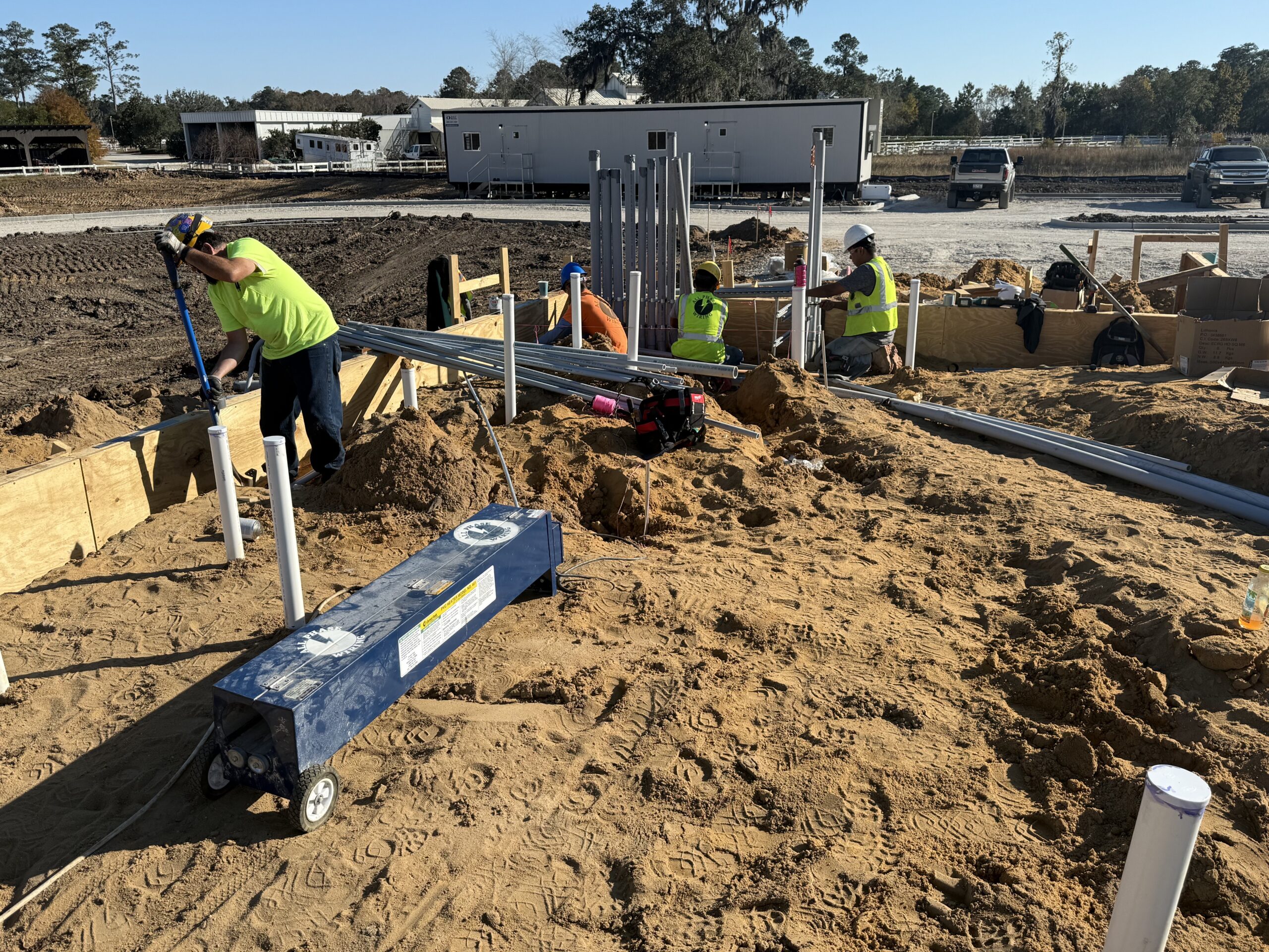 Construction workers preparing a site with wooden frames and pipes.
